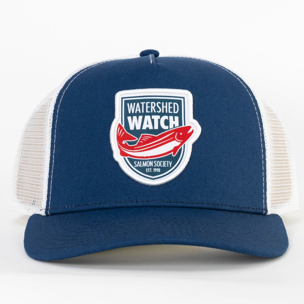 A Navy / White trucker hat with white mesh side panels and a front patch reading 'WATERSHED WATCH' with a red salmon graphic and 'Salmon Society Est. 1998'.