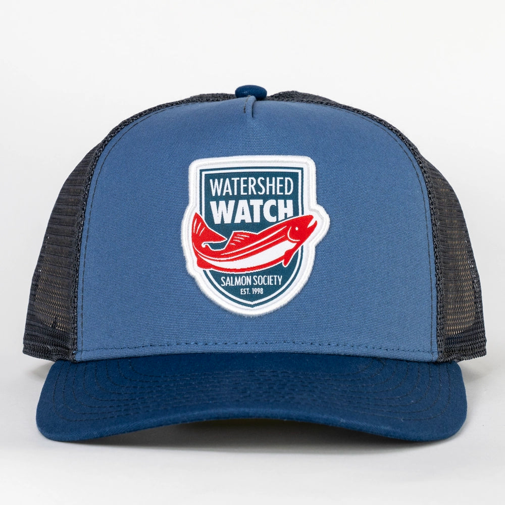 A Dusk Blue / Navy trucker hat with a 'Watershed Watch' salmon logo patch on the front, set against a clean white background.